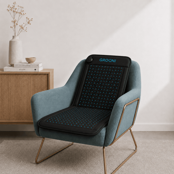 Blue armchair with a black massage pillow labeled 'GROON!' in a room setting.