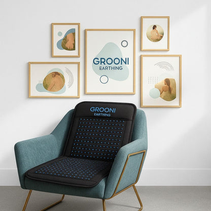 Blue armchair with a black Grooni Earthing mat against a white wall with framed artwork.