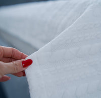 Close-up of a hand with red nail polish holding white grounding blanket