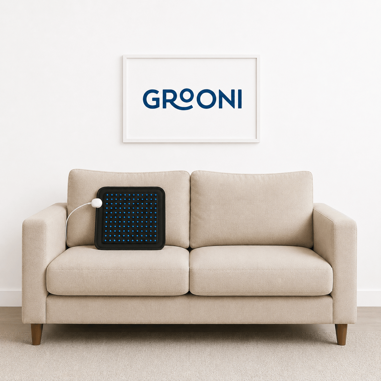 Beige sofa with a black electronic device on it, Groooni logo in the background