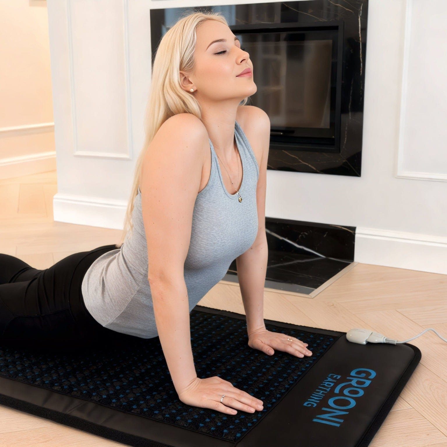Woman over a PEMF Mat doing a yoga pose looking relaxed in the comfort of her home