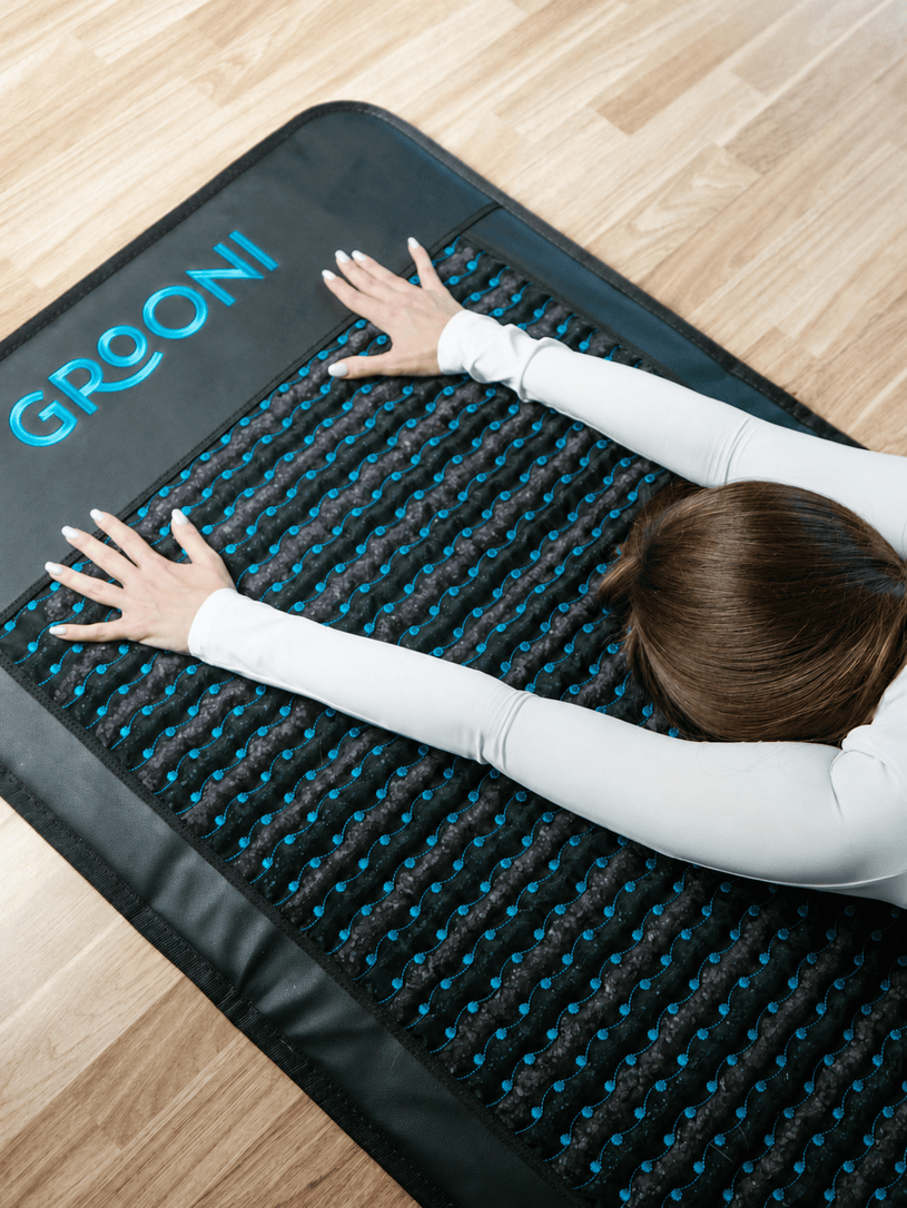 Woman using Grooni PEMF mat at home