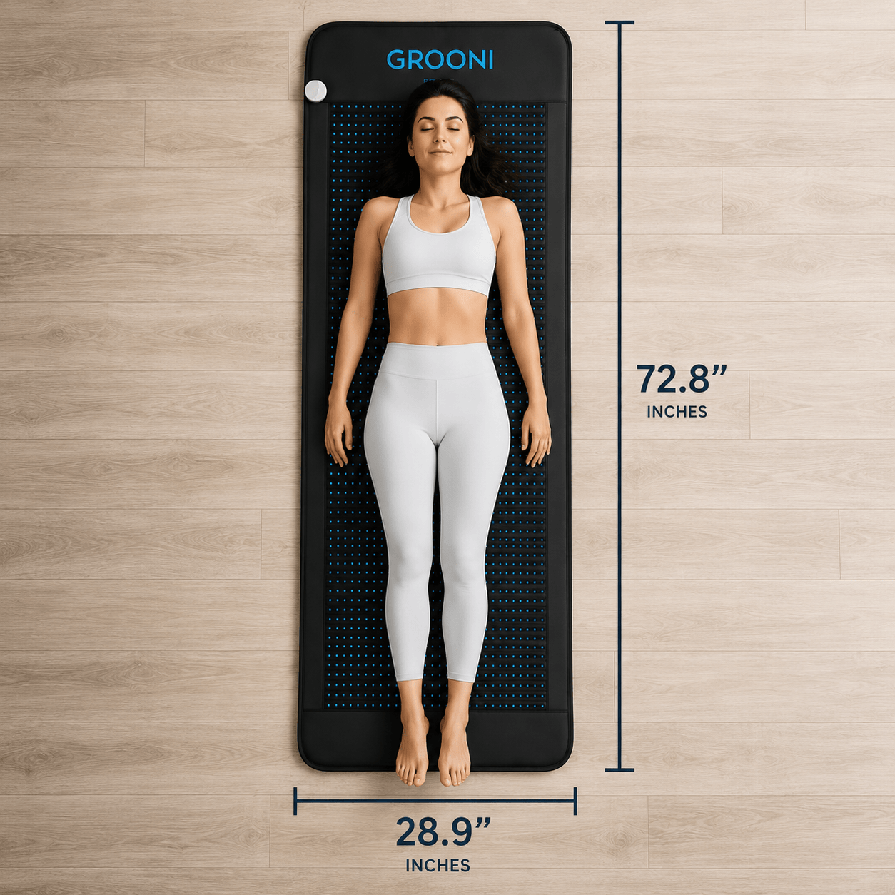 Woman lying on a Grooni mat with dimensions indicated, on a wooden floor background