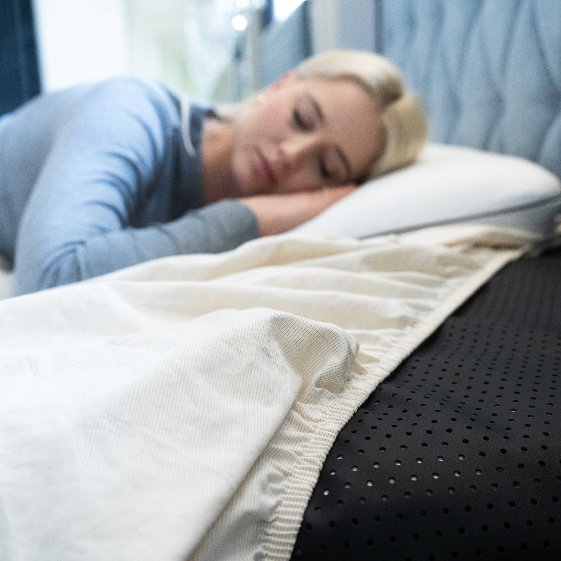 A woman sleeping profoundly and comfortably  while using a earthing mat 